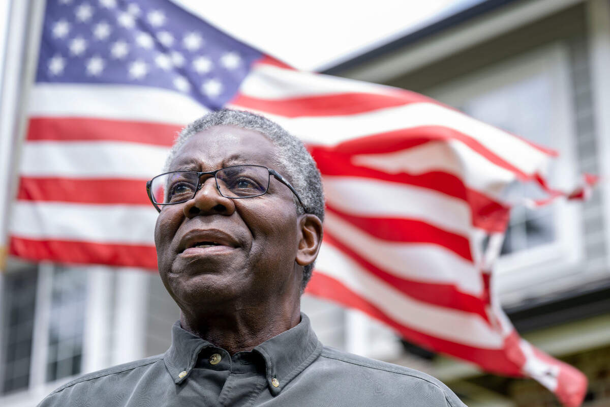 Samuel Jones poses for a photo in front of an American flag outside of his house in Puyallup, Wash., on Wednesday, June 14, 2023.