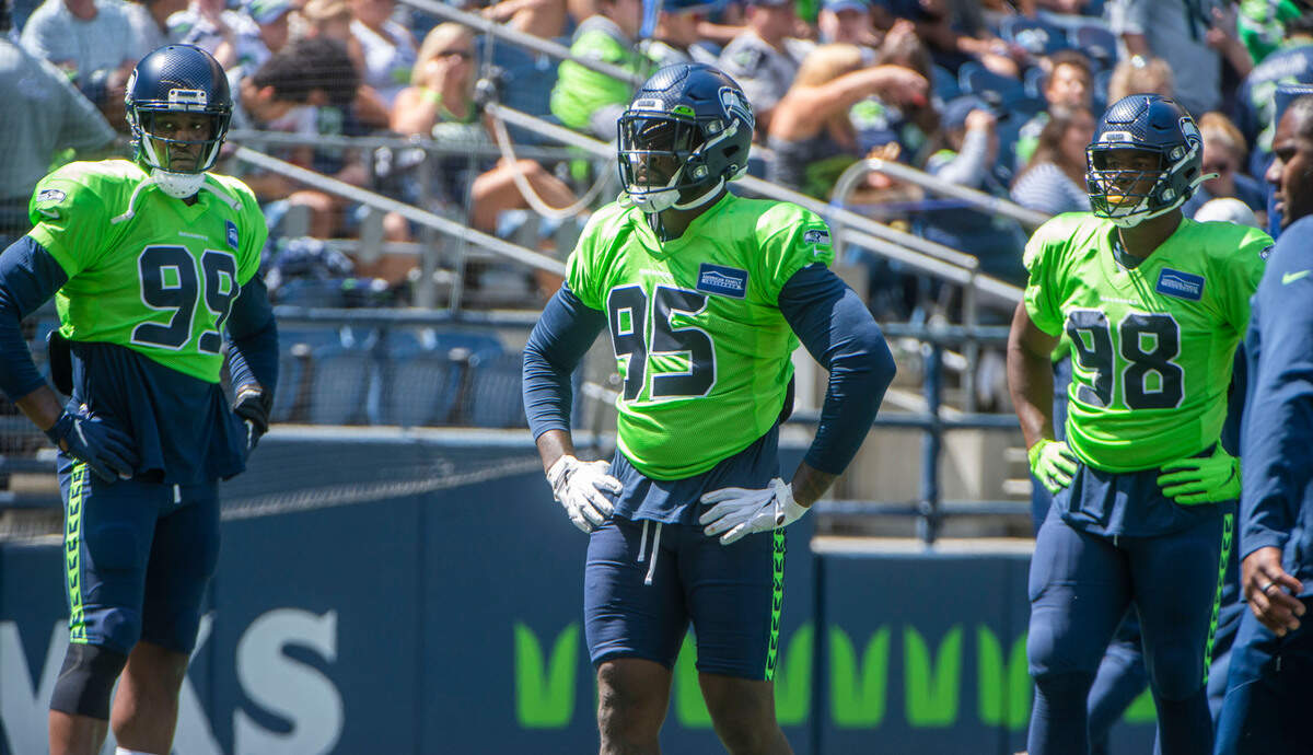 Seahawks defensive linemen Aldon Smith, left, Benson Mayowa and Alton Robinson prior to the annual training camp mock game at Lumen Field in Seattle on August, 5, 2021.