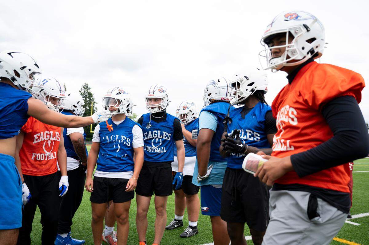 Players huddle before running a play during a football practice at Graham-Kapowsin High School, on Thursday, Aug. 22, 2024, in Graham, Wash.