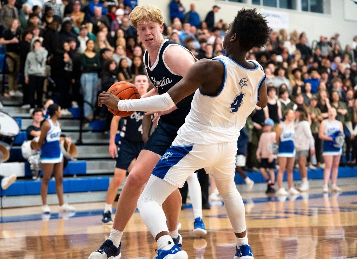 Olympia’s forward Andreas Engholm (2) shoves Curtis’s forward Josiah Johnson (4) while driving to the basket during a basketball game at Curtis High School in University Place, Wash. on Jan. 7, 2023. Olympia defeated Curtis 72-60.
