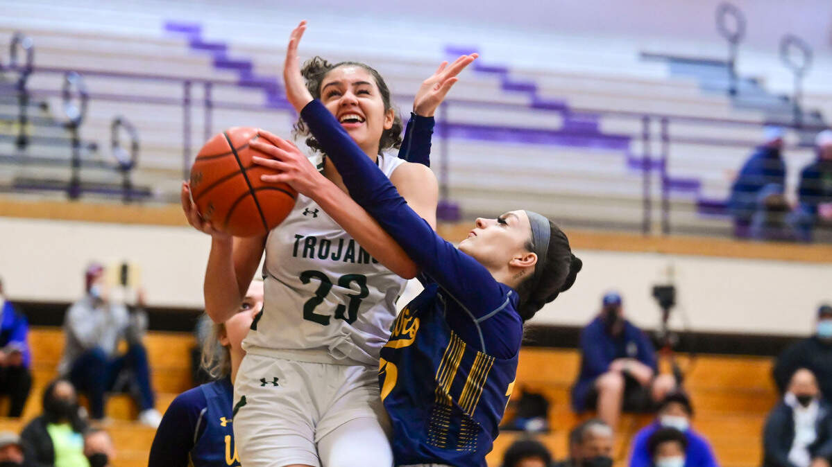 Auburn guard Madelyn Brown (23) drives to the basket for a layup as West Seattle forward Kaydinse Piersol (10) defends during the second quarter of a Class 3A state regional play-in game on Friday, Feb. 25, 2022, at Puyallup High School in Puyallup, Wash.