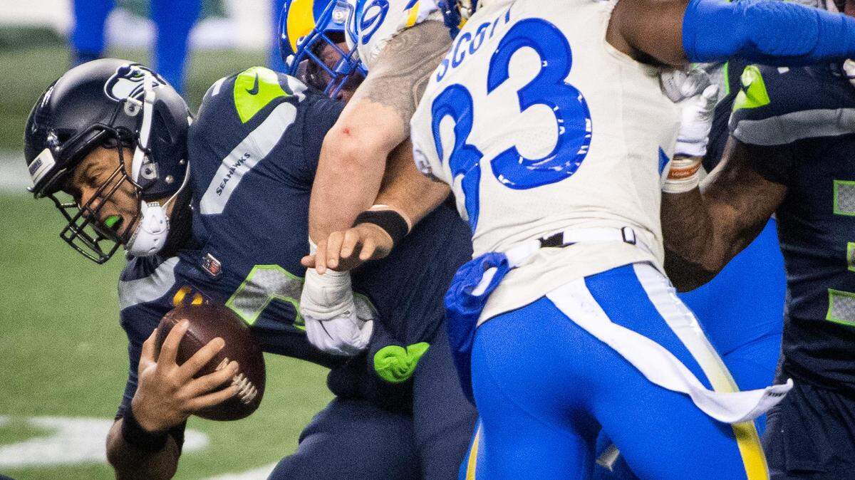 Seattle Seahawks quarterback Russell Wilson is sacked by Los Angeles Rams defensive end Morgan Fox on the final drive of the game. The Seattle Seahawks played the Los Angeles Rams in a NFL wildcard playoff game at Lumen Field in Seattle, Wash., on Saturday, Jan. 9, 2021.