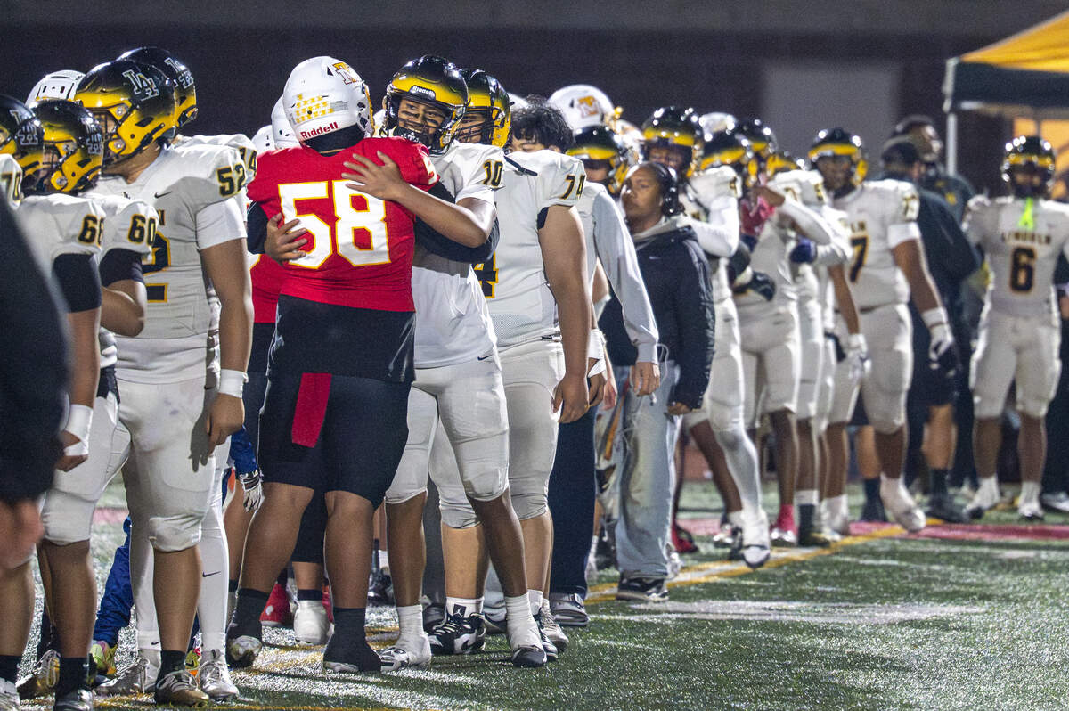 Mount Tahoma defensive tackle Chronicles Tauave (58) hugs Lincoln quarterback Sione Kaho (10) after Mount Tahoma’s win over the Abes on Saturday, Nov. 22, 2025, in Tacoma, Wash.