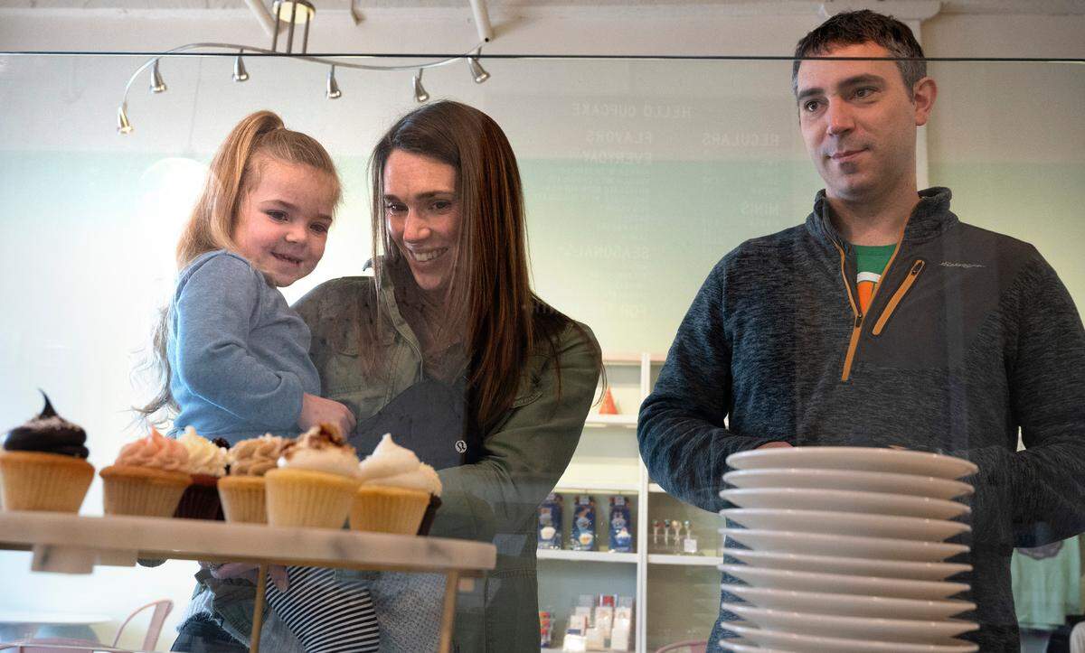 The Novotney family of Gig Harbor (from left), Thea, 3, Cecily and Jon, make their selections at Hello Cupcakes in downtown Tacoma, Washington, on Thursday, Jan. 5, 2023. The store will close on Sunday after 15 years.