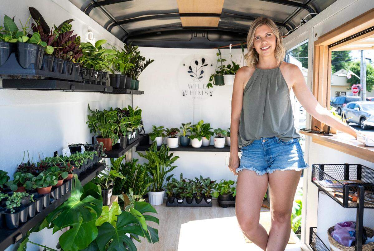 Wild Whimsy Plant Co. owner Salena Ausburn poses for a portrait inside of her mobile plant shop on Harborview Drive in Gig Harbor, Wash. on Thursday, July 21, 2022.