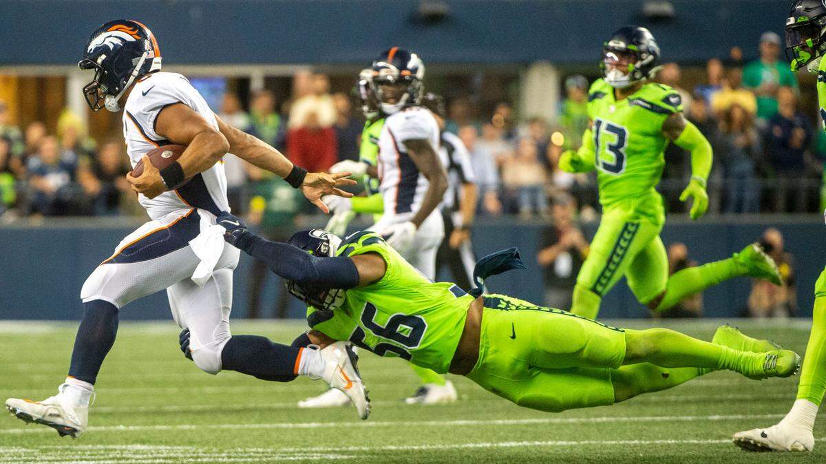 Seattle Seahawks linebacker Jordyn Brooks (56) attempts to tackle Denver Broncos quarterback Russell Wilson (3) during the fourth quarter of an NFL game on Monday, Sept. 12, 2022, at Lumen Field in Seattle.