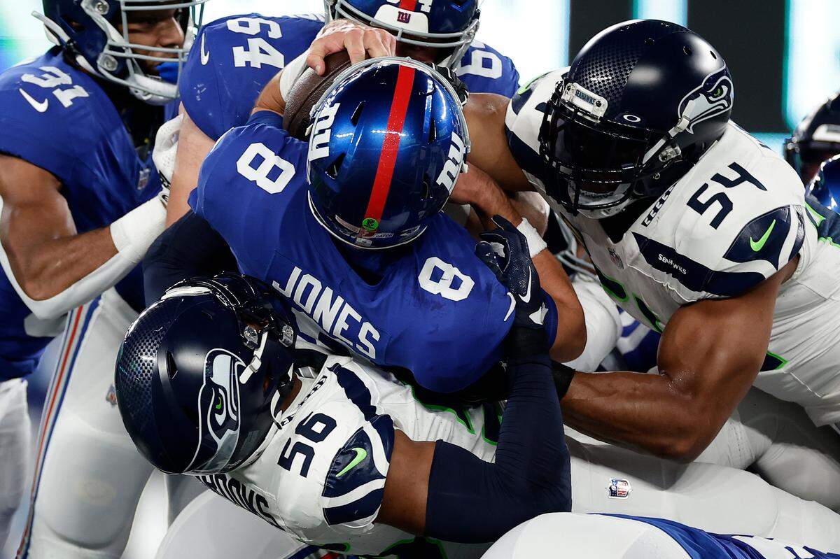 New York Giants quarterback Daniel Jones (8) is sacked by Seattle Seahawks linebacker Jordyn Brooks (56) and Seattle Seahawks linebacker Bobby Wagner (54) during the first quarter of an NFL football game, Monday, Oct. 2, 2023, in East Rutherford, N.J. (AP Photo/Adam Hunger)