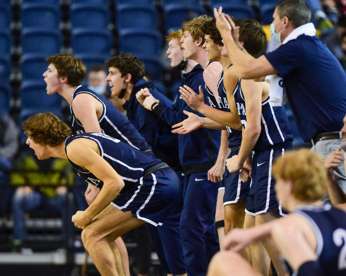 The Olympia celebrate after a blocked shot by teammate forward Cree Barna (54) during the second quarter of a Class 4A quarterfinal state tournament game against Tahoma on Thursday, March 3, 2022, at the Tacoma Dome, in Tacoma, Wash.