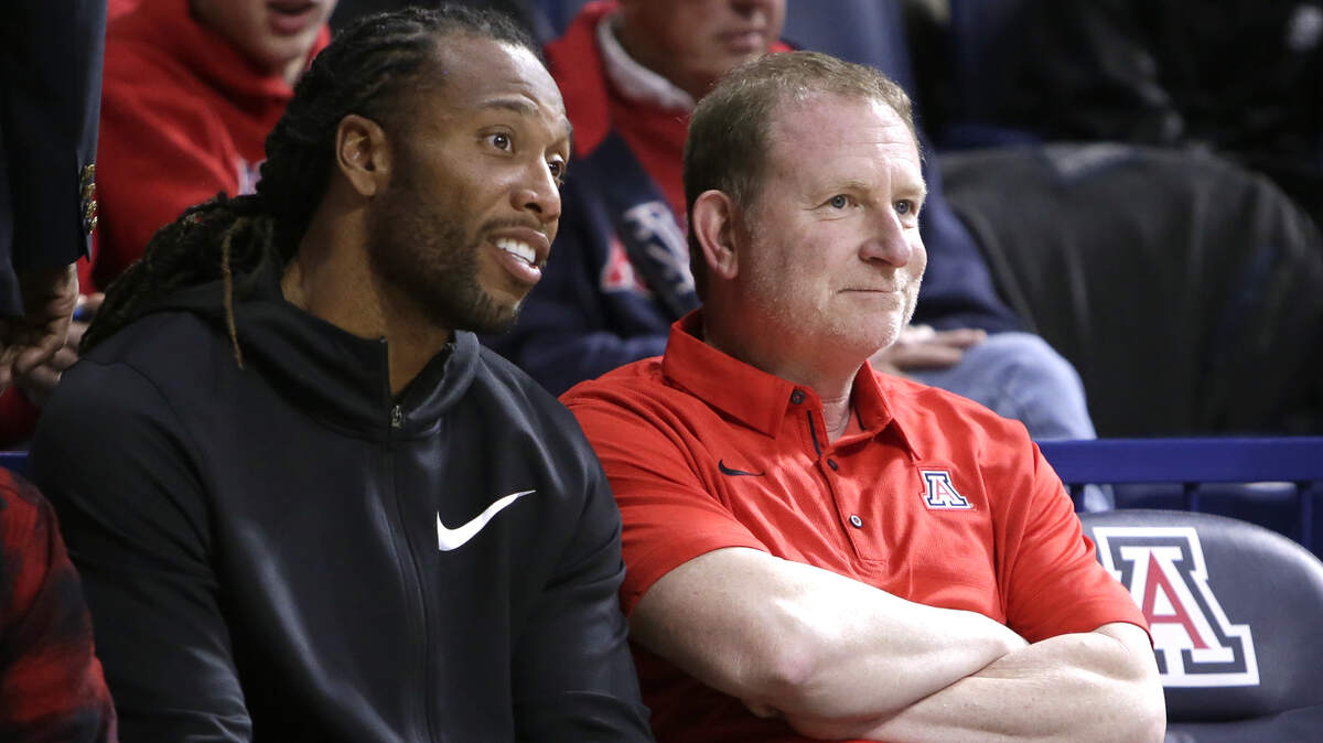 Arizona Cardinals player Larry Fitzgerald and Phoenix Suns owner Robert Sarver watch an NCAA college basketball game between Arizona and Connecticut on Thursday, Dec. 21, 2017, in Tucson, Ariz. Arizona defeated Connecticut 73-58. (AP Photo/Rick Scuteri)