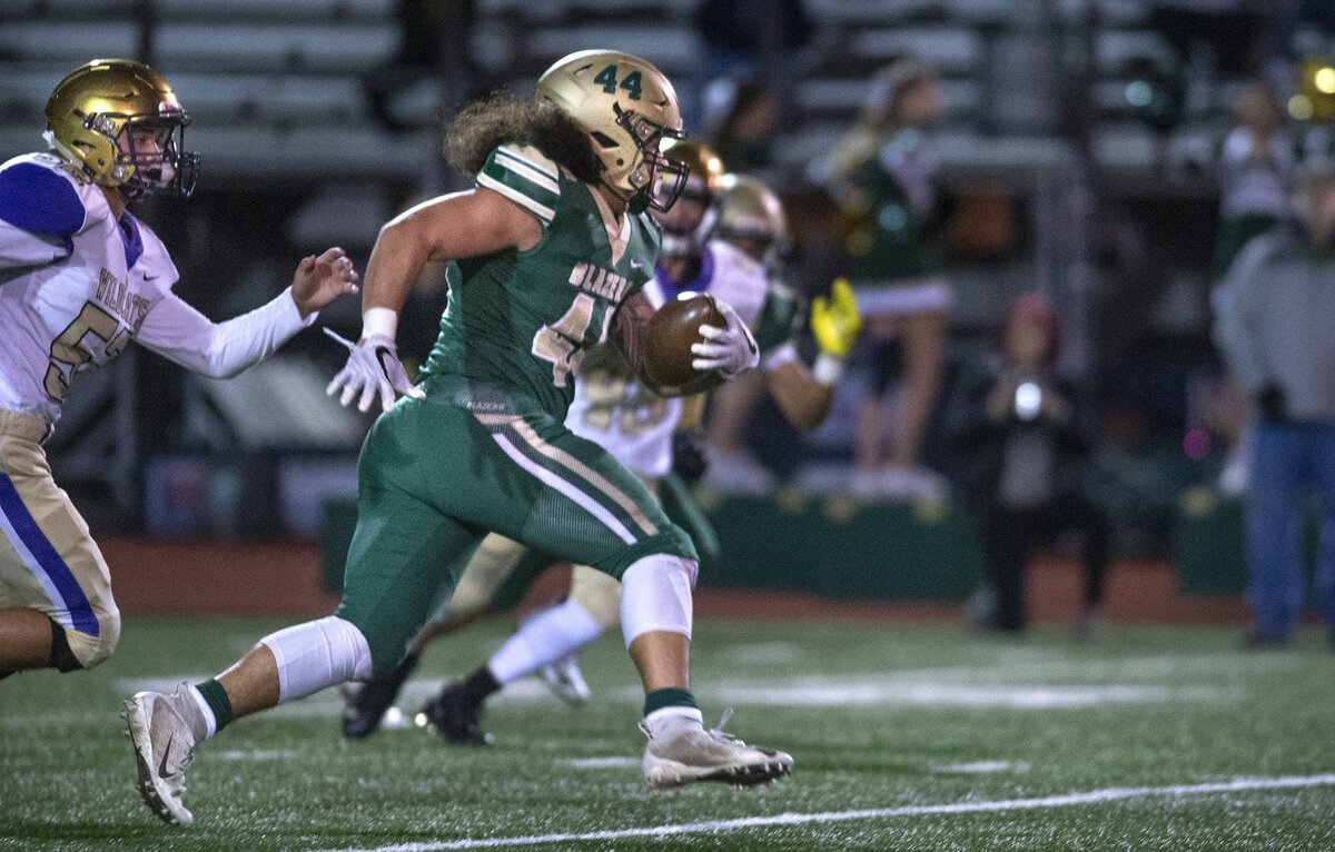Timberline linebacker Jamin Fa’alogo sprints up field with an interception in front of Oak Harbor’s Michael Gomez during Friday night’s football game at South Sound Stadium in Lacey on Nov. 2, 2018.