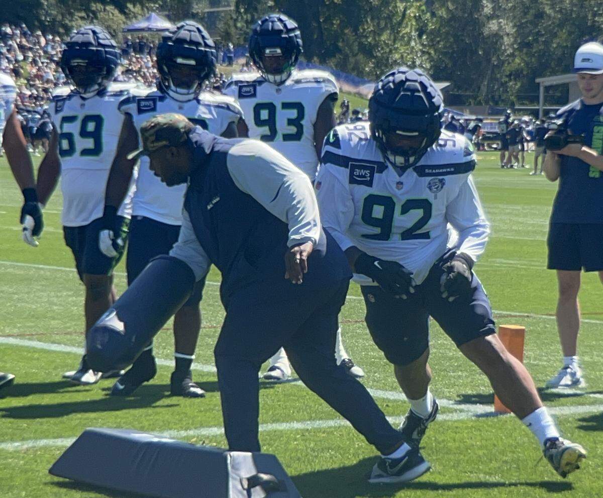 Tackle Quinton Bohanna (92) works a drill with defensive line coach Justin Hinds at Seattle Seahawks NFL training camp Aug. 12, 2025, at the Virginia Mason Athletic Center in Renton.