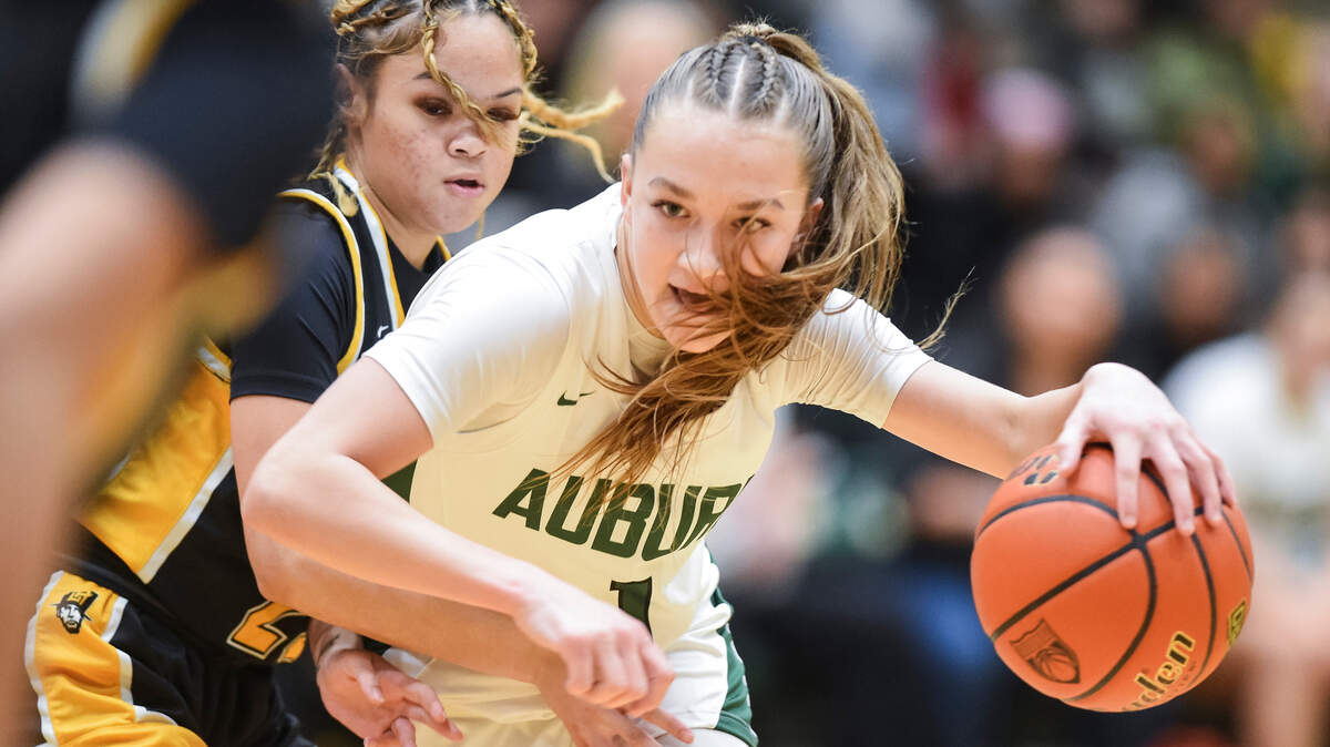 Auburn’s Avery Hansen (1) tries to cut around Lincoln’s Jaleigha Robinson (23) during the opening round of the 3A District 3/4 basketball tournament at Auburn High School on Friday, Feb. 9, 2024, in Auburn, Washington.