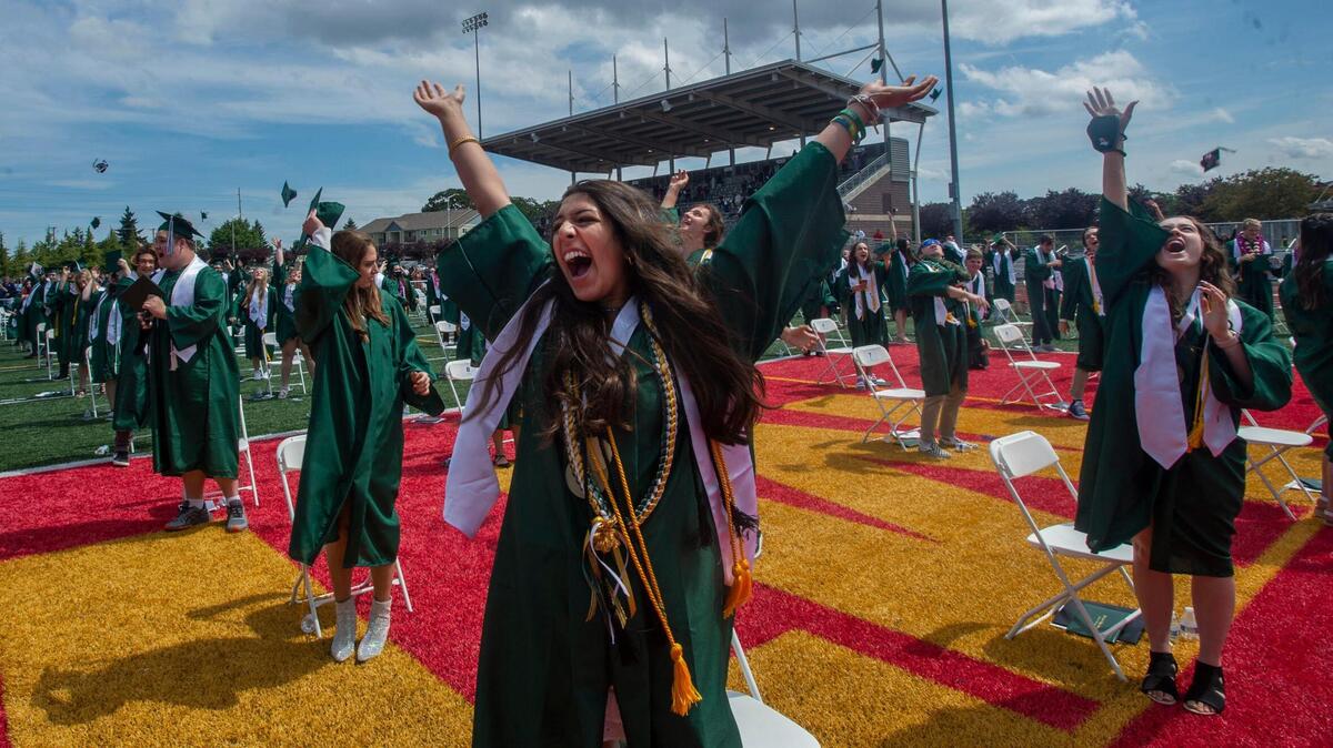 Audrey Krishnadasan and her Peninsula High School classnates celebrate their graduation by sending mortarboards soating after back-to-back ceremonies for both Gig Harbor high schools on Saturday, June 11, 2021. The events were staged for social distancing at Mount Tahoma High in Tacoma.