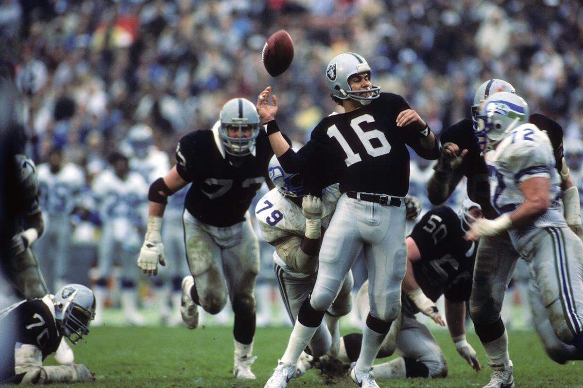 LOS ANGELES - JANUARY 8: Quarterback Jim Plunkett #16 of the Los Angeles Raiders fumbles the ball during the 1983 AFC Conference Championship game against the Seattle Seahawks at the Los Angeles Memorial Coliseum on January 8, 1984 in Los Angeles, California. The Raiders won 30-14. (Photo by George Rose/Getty Images)