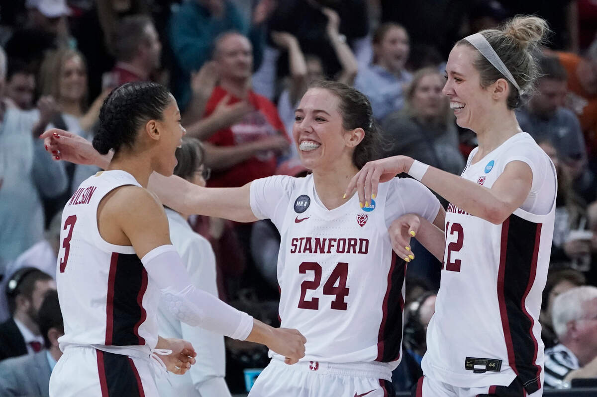 Stanford guards and twin sisters Lacie Hull (24) and Lexie Hull (12) greet guard Anna Wilson (3) after a college basketball game against Texas in the Elite 8 round of the NCAA tournament, Sunday, March 27, 2022, in Spokane, Wash. Stanford won 59-50. (AP Photo/Ted S. Warren)