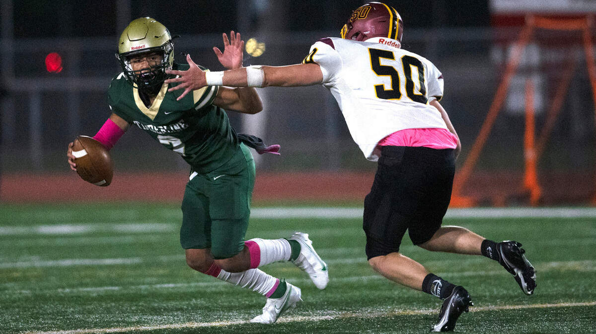 Timberline quarterback Franco Segura scrambles away from Capital defensive end Hunter Maki during Friday night’s 3A SSC football game at South Sound Stadium in Lacey, Washington, on Oct. 8, 2021.
