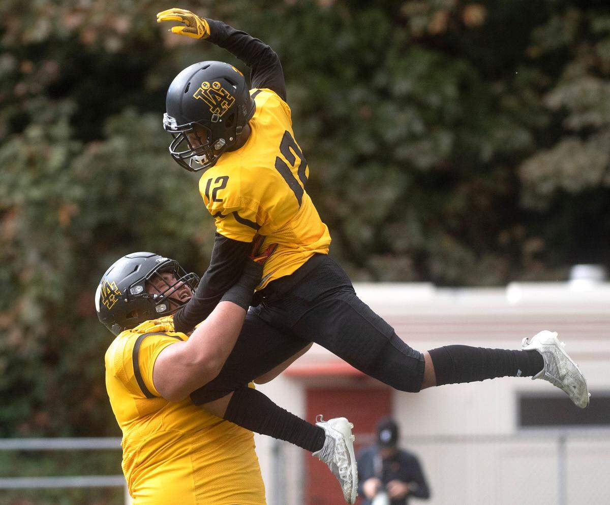Lincoln wide receiver DJ Ervin is lifted by teammate TJ Tusi as they celebrate Ervin’s touchdown reception during Saturday afternoon’s football game against the Lakes Lancers at Lincoln Bowl in Tacoma, Washington, on Oct. 22, 2022.