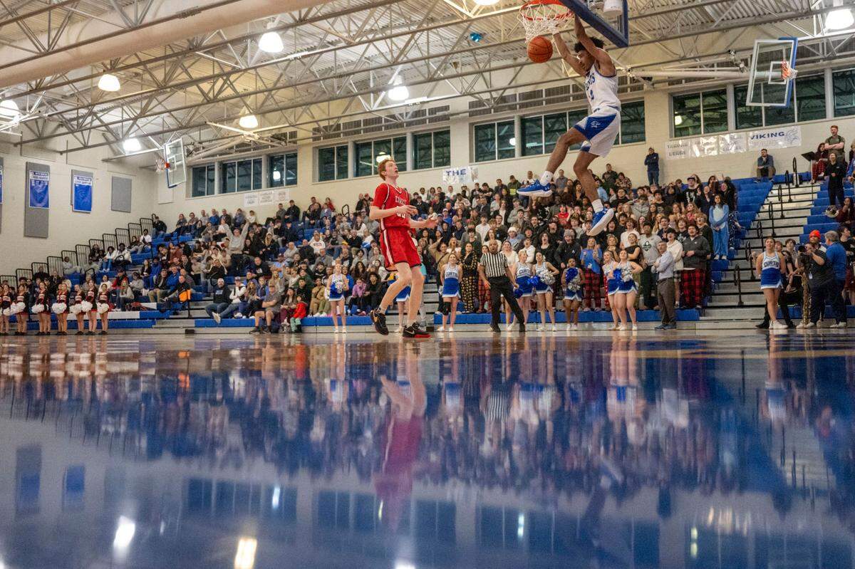 Curtis guard Cinque Maxwell (12) dunks the ball on a fast break as Camas forward Ethan Harris (35) gets back on defense during the fourth quarter of a District 3/4 semifinal game on Thursday, Feb. 16, 2023, at Curtis High School in University Place, Wash.