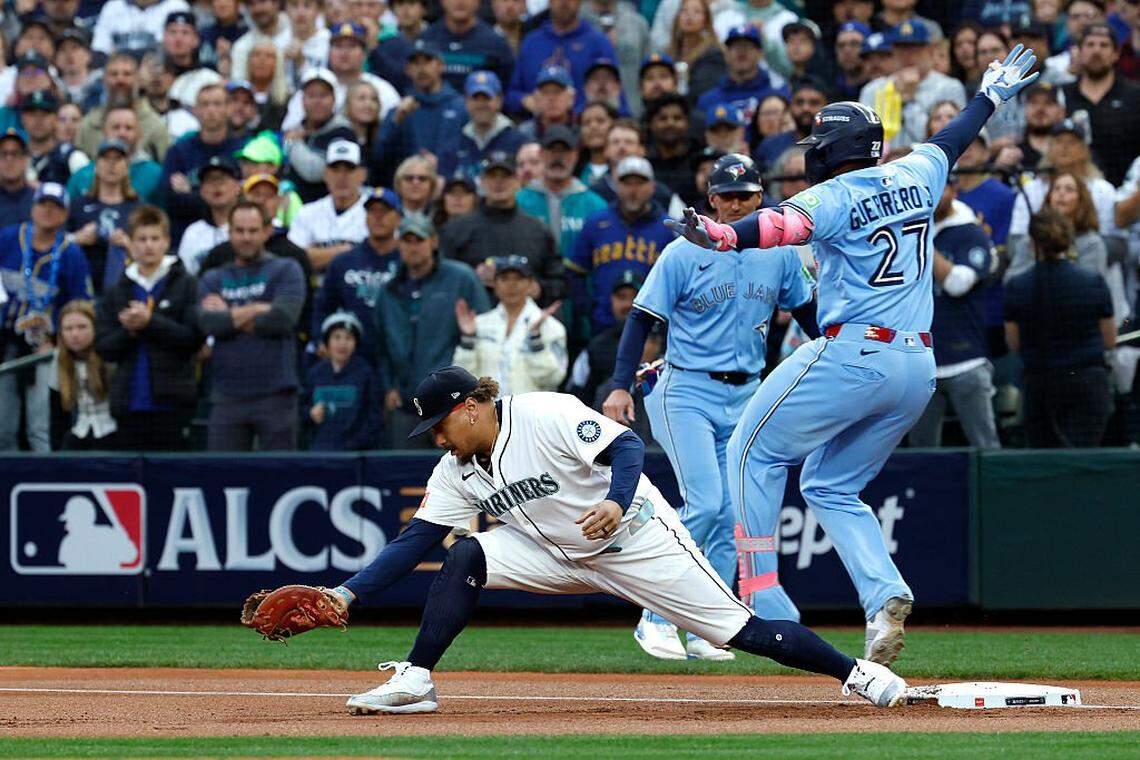 SEATTLE, WASHINGTON - OCTOBER 16: Vladimir Guerrero Jr. #27 of the Toronto Blue Jays is forced out at first base by Josh Naylor #12 of the Seattle Mariners during the first inning in game four of the American League Championship Series at T-Mobile Park on October 16, 2025 in Seattle, Washington. (Photo by Alika Jenner/Getty Images)