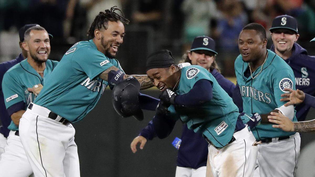 Seattle Mariners’ Mallex Smith, center, is mobbed by teammates, including J.P. Crawford, second from left, and Tim Beckham, second from right, after Smith hit a walk-off RBI single in the ninth inning of a baseball game against the Detroit Tigers to score Kyle Seager and give the Mariners a 3-2 win, Friday, July 26, 2019, in Seattle.