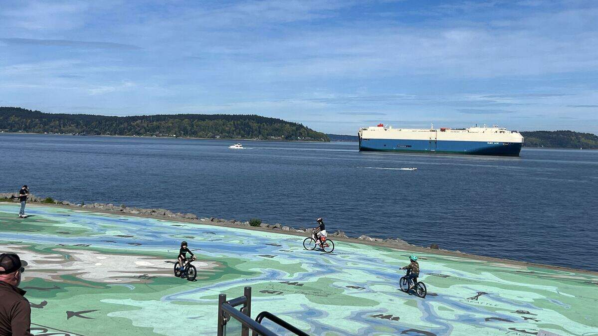 Children ride bicycles along Point Ruston as the Japanese vehicle carrier Ruby Ace float in Commencement Bay on Saturday, April 18, 2026.
