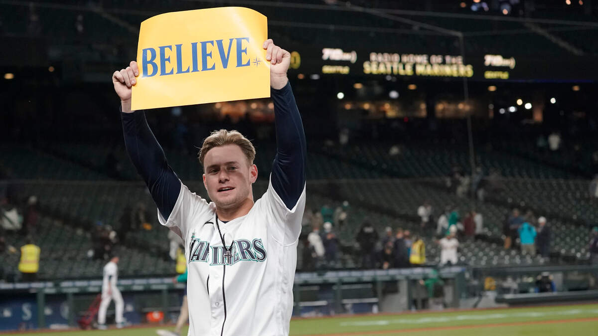 Seattle Mariners’ Jarred Kelenic holds up a sign that read “Believe” after the Mariners beat the Oakland Athletics 4-2 in a baseball game, Wednesday, Sept. 29, 2021, in Seattle. Fans and the team have adopted the one-word slogan that was recently featured on the TV series “Ted Lasso” as the Mariners battle for a spot in the MLB playoffs. (AP Photo/Ted S. Warren)