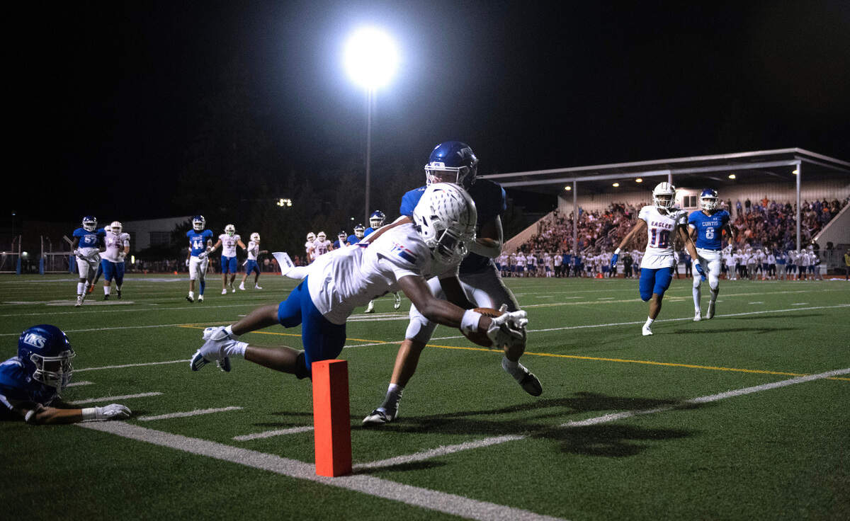 Graham Kapwosin wide receiver Khris Norris dives into the end zone for a touchdown ahead of Curtis defensive back Micah Yanos during Friday night’s 4A SPSL football game at Viking Stadium in University Place, Washington, on Oct. 6, 2023. Graham Kapowsin won the game, 42-35.