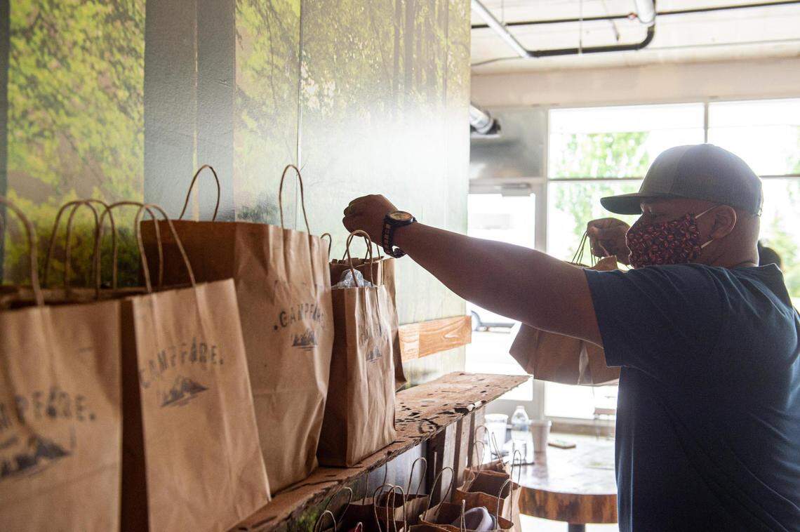 Quincy Henry prepares pick-up bags of coffee beans at Campfire Coffee in Tacoma, Wash., on Thursday, July 23, 2020.