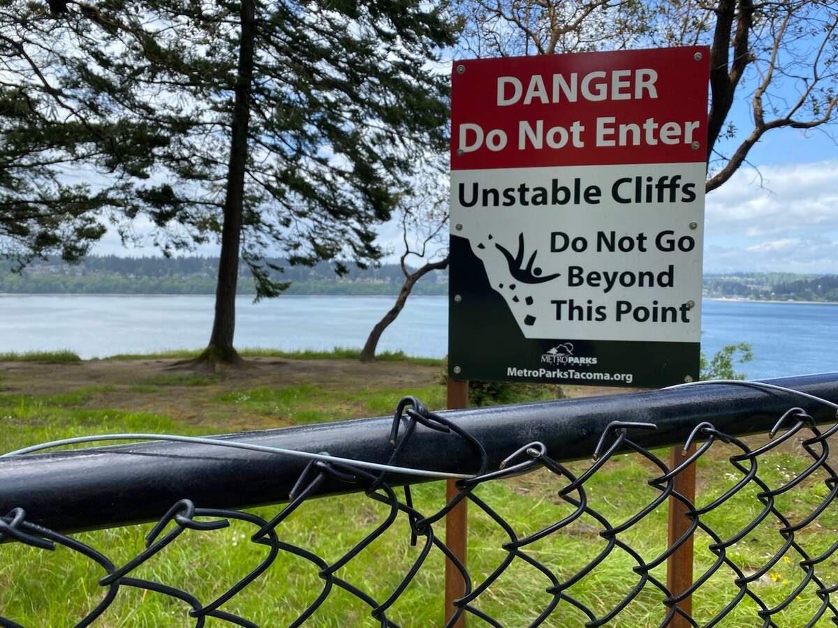 A sign and fencing is meant is to keep visitors away from dangerous cliffs along the Five Mile Drive Wednesday at Point Defiance Park in Tacoma. The drive closes to vehicle traffic on Thursday afternoon.