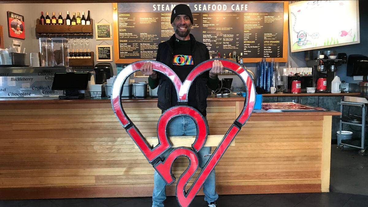 Tacoma artist John James Nelson with the recovered 253 heart inside Steamers Seafood Cafe on Tuesday.