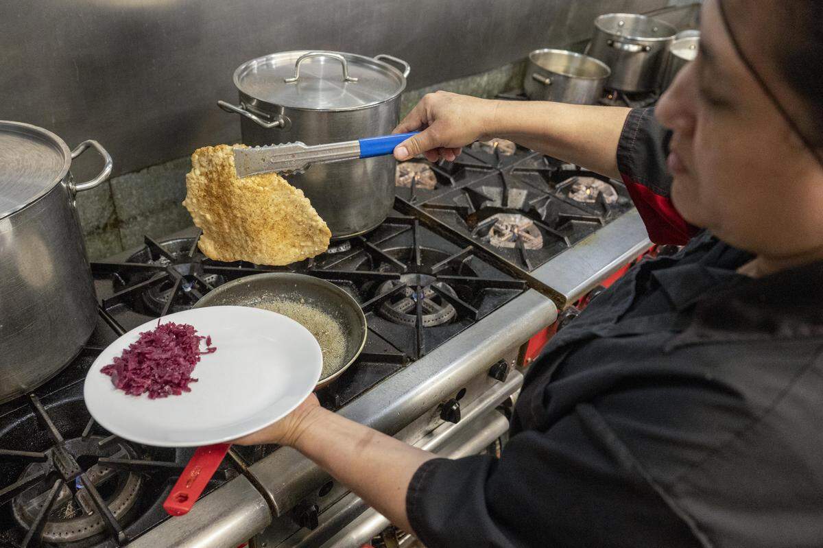 Maria Agyelar, a cook at Bruno's European Restaurant, prepares a schnitzel plate on Wednesday, Oct. 8, 2025, in Lakewood, Wash.