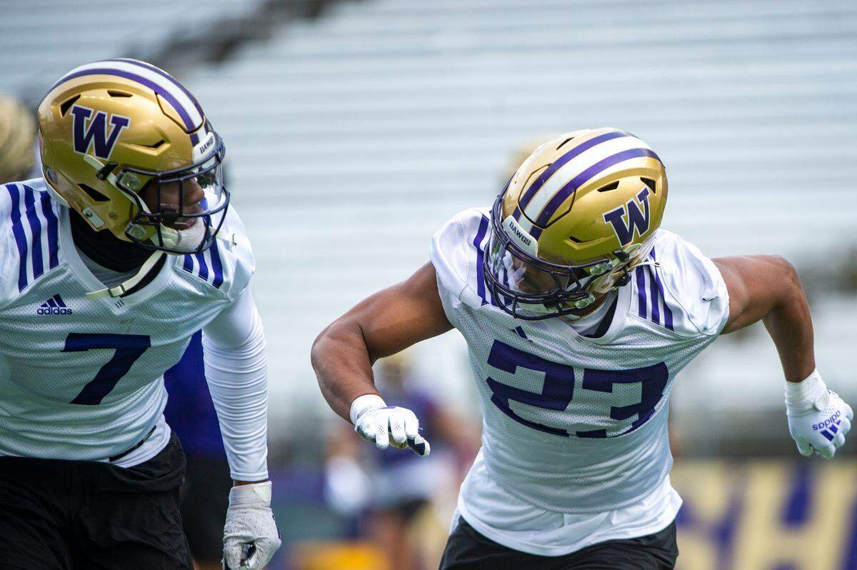 Washington cornerback Mishael Powell (23) runs through drills with Dominique Hampton at spring practice on Wednesday, March 30, 2022, at Husky Stadium in Seattle, Wash.