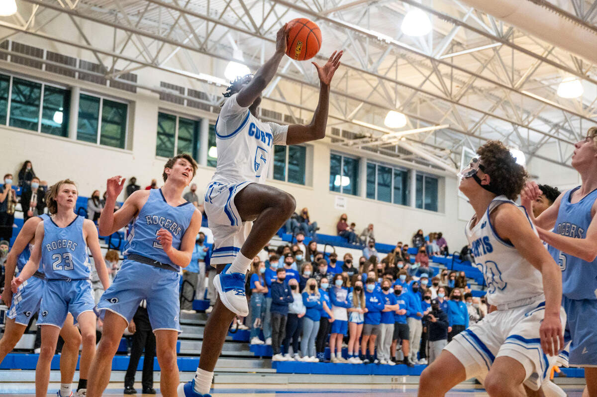 Curtis guard Zoom Diallo (5) drives to the basket past Rogers guard Spencer Barnes (3) during the first quarter of a 4A South Puget Sound League tournament semifinal game on Friday, Feb. 4, 2022, at Curtis High School in University Place, Wash.