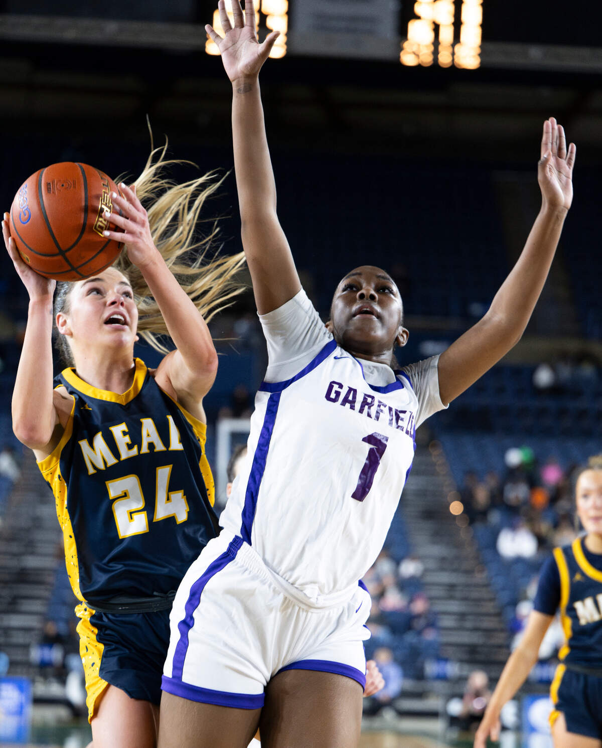 Mead’s Teryn Gardner (24) drives in against Garfield’s Star Smiley (1) during the Class 3A state championship game at the Tacoma Dome, on Saturday, March 2, 2024, in Tacoma, Wash.