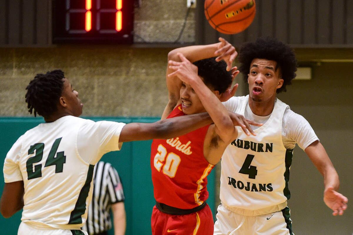 Auburn guard Dae’Kwon Watson (24) knocks the ball away from Mount Tahoma guard Asjon Anderson (20) as guard Amar Rivers (4) looks on during the first quarter of a non-league game on Thursday, Jan. 20, 2022, at Auburn High School.