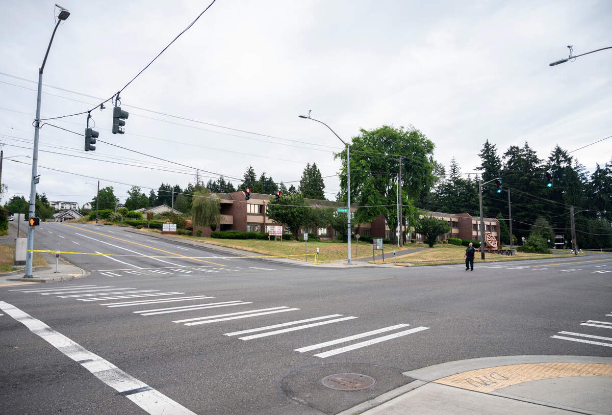 An officer and crime scene technician investigate a drive by shooting at the intersection of South Tacoma Way and South 47th Street in Tacoma, Wash. on Sunday, July 3, 2022. An adult male was shot in a vehicle and transported to the hospital with serious injuries, according to the Tacoma Police Department.