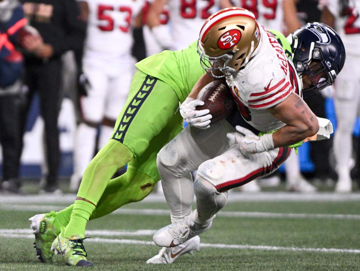 Seattle Seahawks safety Quandre Diggs (6) tackles San Francisco 49ers running back Christian McCaffrey (23) during the third quarter of the game at Lumen Field, Thursday, Nov. 23, 2023, in Seattle, Wash.