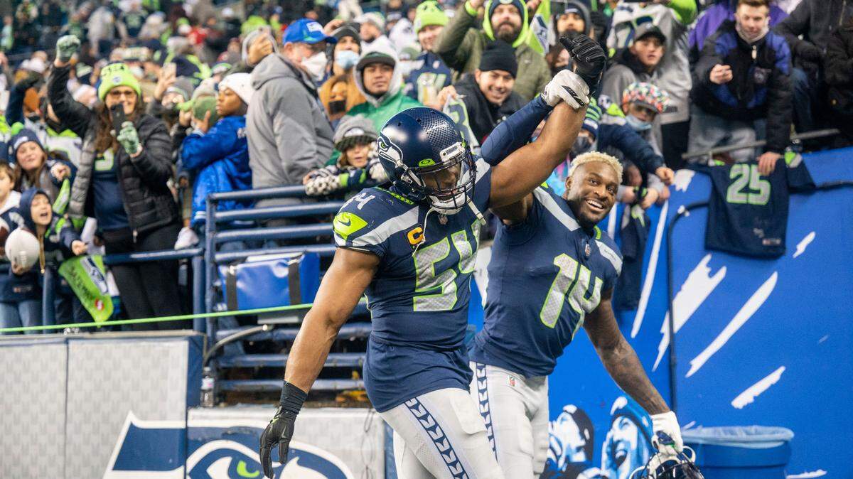 Seahawks wide receiver DK Metcalf (14) lifts up the arm of middle linebacker Bobby Wagner (54) after Wagner and the defense helped Seattle beat San Francisco 49ers, 30-23, on Sunday at Lumen Field in Seattle.
