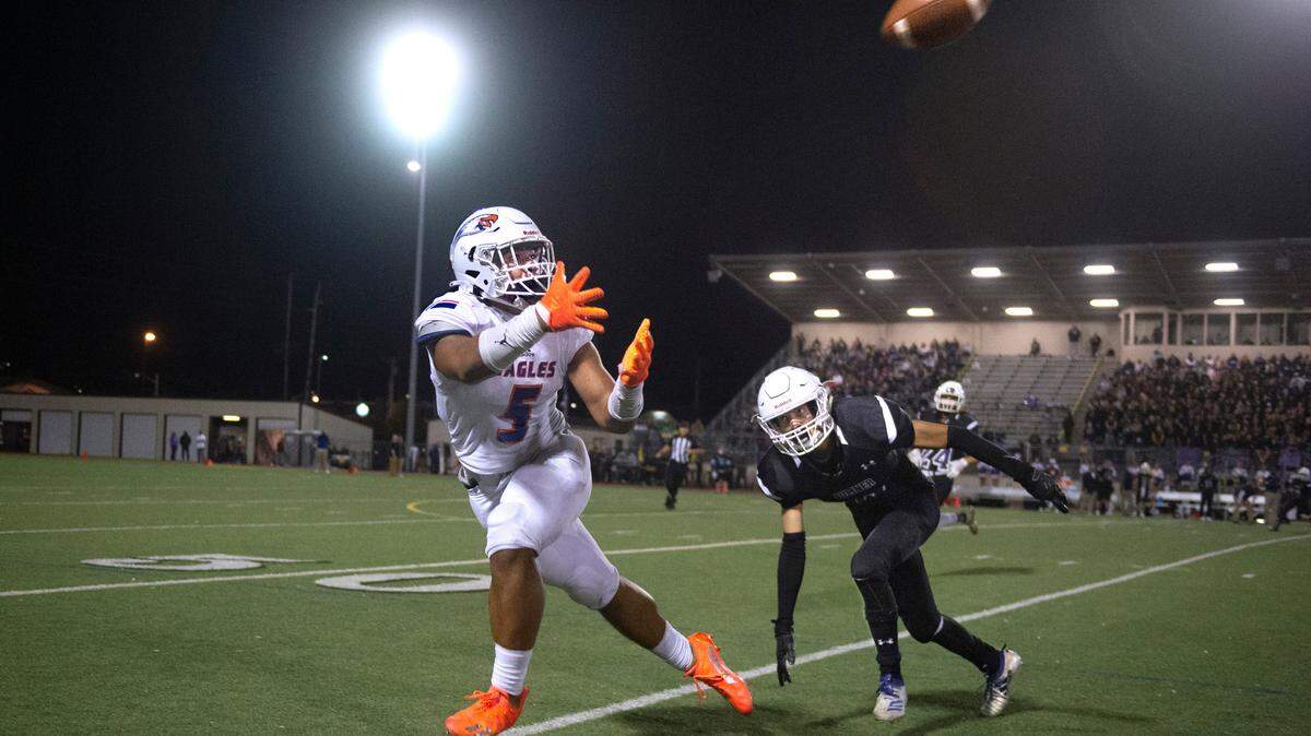 Graham-Kapowsin tight end Andrew Savainaea pulls in a sideline pass in front of Sumner defensive back Jalen Jordan during Saturday night’s 4A SPSL high school football game at Sunset Chev Stadium in Sumner, Washington, on Oct. 16, 2021. Graham-Kapowsin won the game, 41-14.
