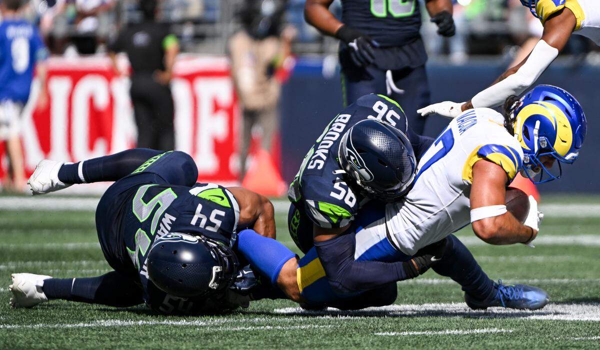 Seattle Seahawks linebacker Bobby Wagner (54) and linebacker Jordyn Brooks (56) bring down Los Angeles Rams wide receiver Puka Nacua (17) during the third quarter of the NFL game at Lumen Field, Sunday, Sept. 10, 2023, Seattle, Wash.