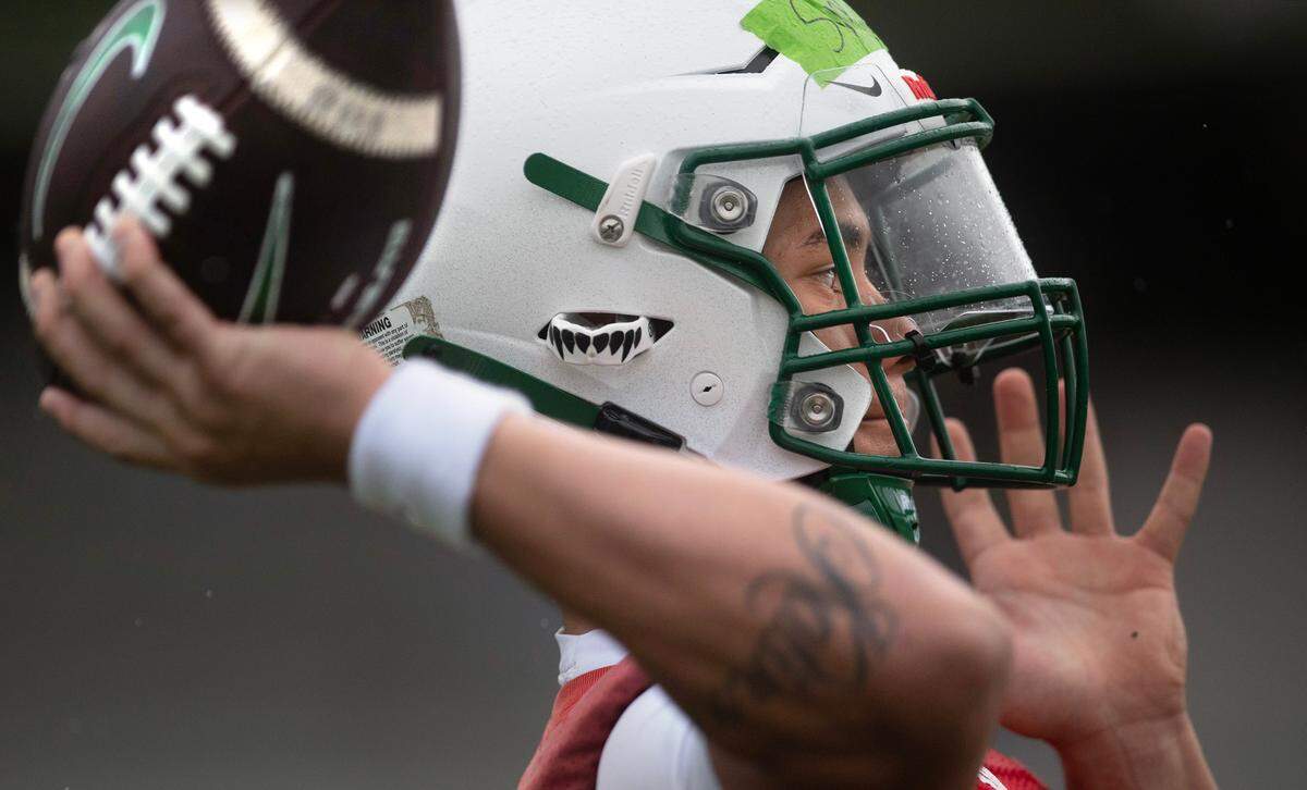 Peninsula quarterback Mana Smythe throws passes during preseason football practice at Peninsula High School in Purdy, Washington, on Friday, Aug. 23, 2024.