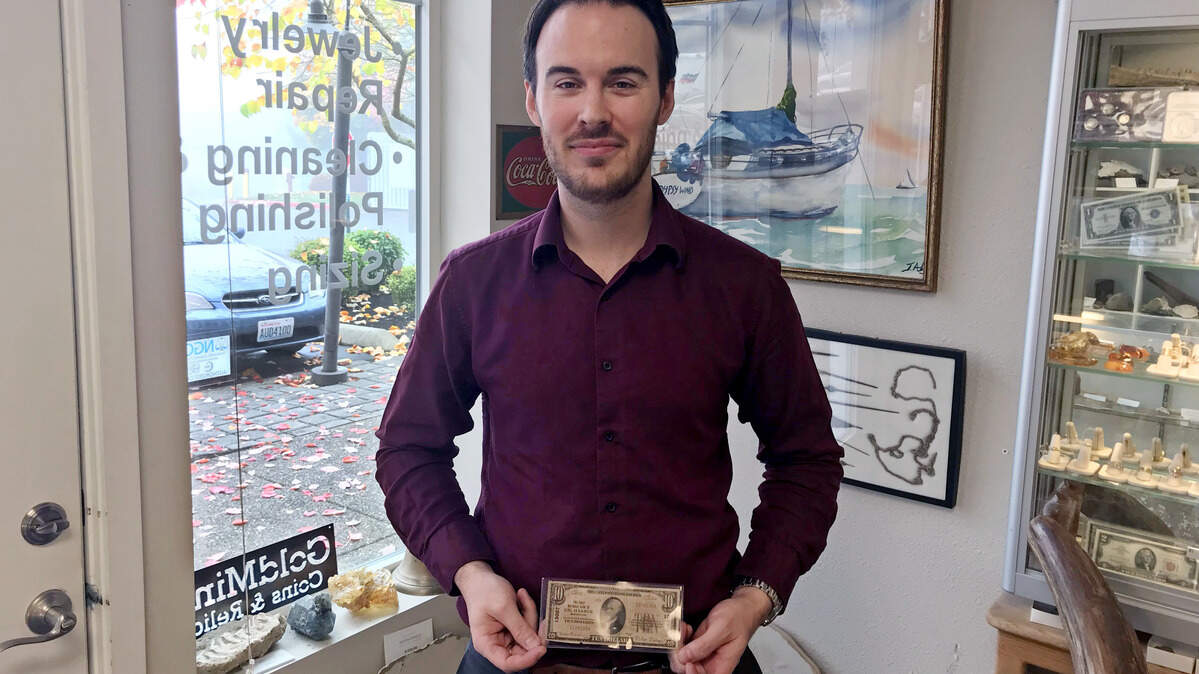David Anderson, owner of Goldmine Coins and Relics, shows off what’s believed to be the only remaining $10 bill issued by the First National Bank of Gig Harbor.