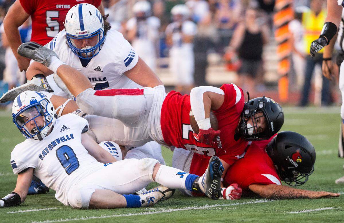 Orting running back Whyatt Phelan (26) trips over Eatonville defensive back Riley Hill (9) while running the ball down the field during the first quarter of a Friday night game at Orting Stadium in Orting Wash. on Sept. 9, 2022.