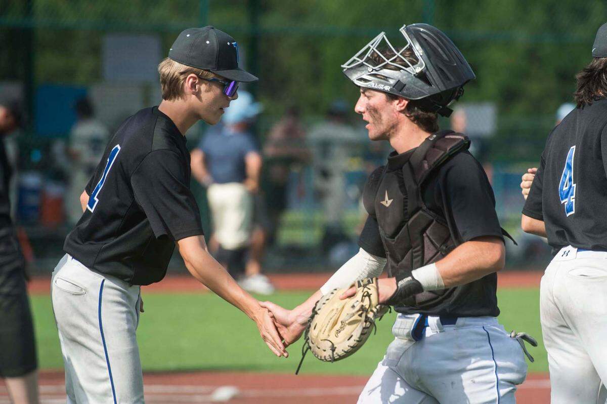 Tahoma catcher Carson Ohland (right) high-fives a teammate following a scoreless inning in a baseball game against Olympia in the Class 4A state quarterfinals on Saturday, May 20, 2023 at the Regional Athletic Complex in Lacey, Wash.