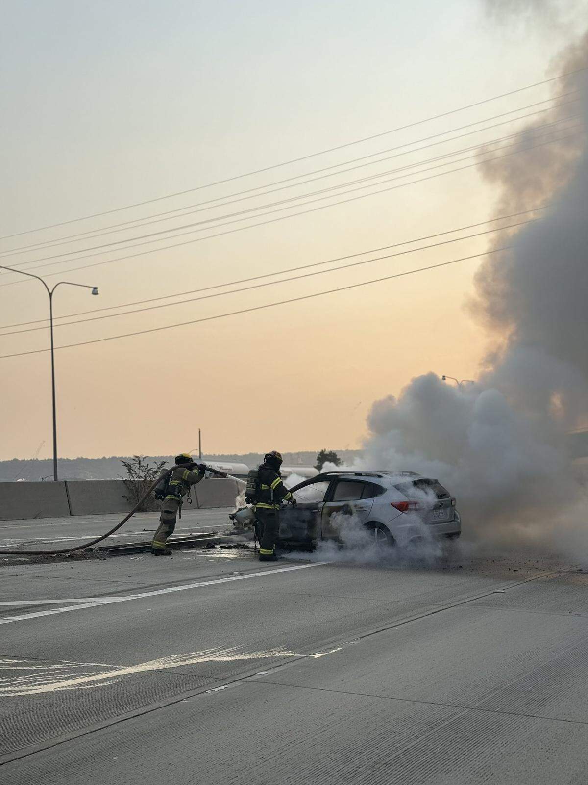 A car burst into flames on I-5 near the Tacoma Dome after it struck a barrier.