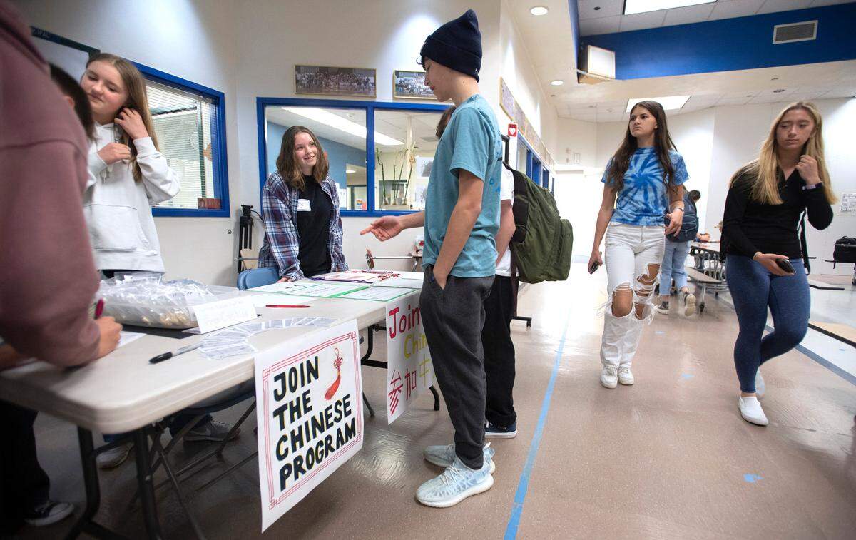Gig Harbor High freshmen Maddie Powell (left) 15, and Ivy Goodkin (center), 14, talk with students at Kopachuck Middle School about the school district’s Chinese language program during a lunch-hour recruitment rally to help save the program in Gig Harbor, Washington, on Friday, April 29, 2022.