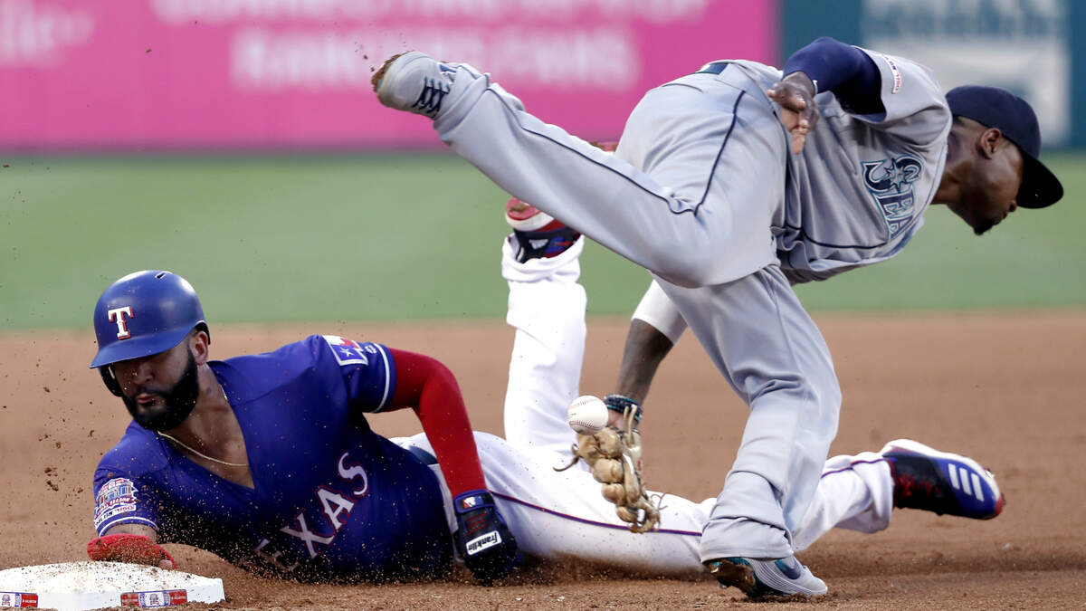 Texas Rangers’ Nomar Mazara (30) steals third as Seattle Mariners third baseman Tim Beckham is unable to field the throw to the bag during the fourth inning of a baseball game in Arlington, Texas, Tuesday, May 21, 2019.