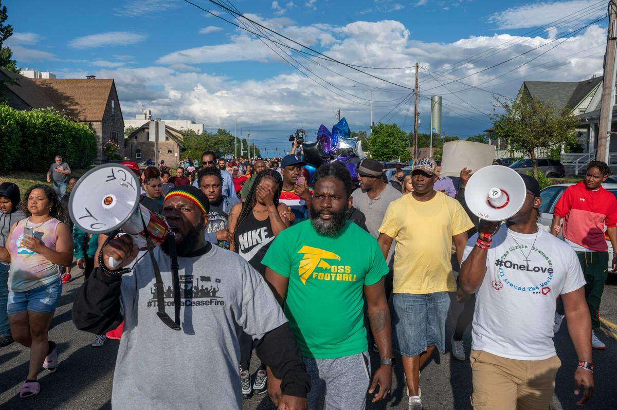 Abdulshahid Muhammad (left-center) leads chants about nonviolence as Kelsey Ussery (center) covers her face as she grieves during a peace walk down South 19th Street in honor of Ussery’s daughter, Iyana, 14, on Thursday, July 7, 2022, in Tacoma, Wash. Iyana Ussery was killed in a shooting on Wednesday, July 6, 2022.