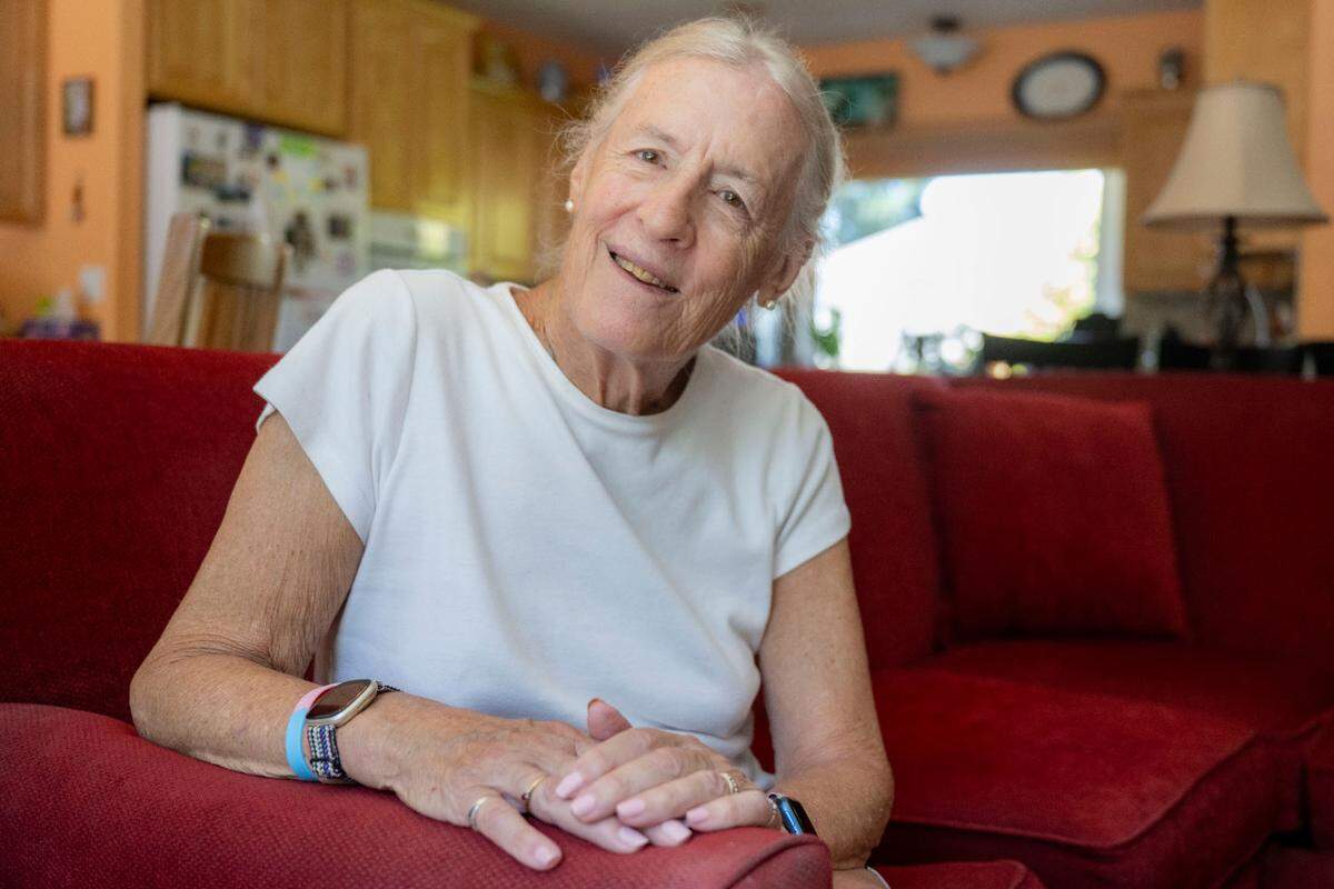 Cheryl, 77, poses for a portrait inside the living room of her Gig Harbor home on Friday, June 30, 2023. Cheryl transitioned at the age of 61 and was soon fired from her job as a construction manager. However, since then, she spends her time volunteering with multiple organizations in Tacoma’s transgender community, while enjoying retirement and spending time with her husband, Tom.
