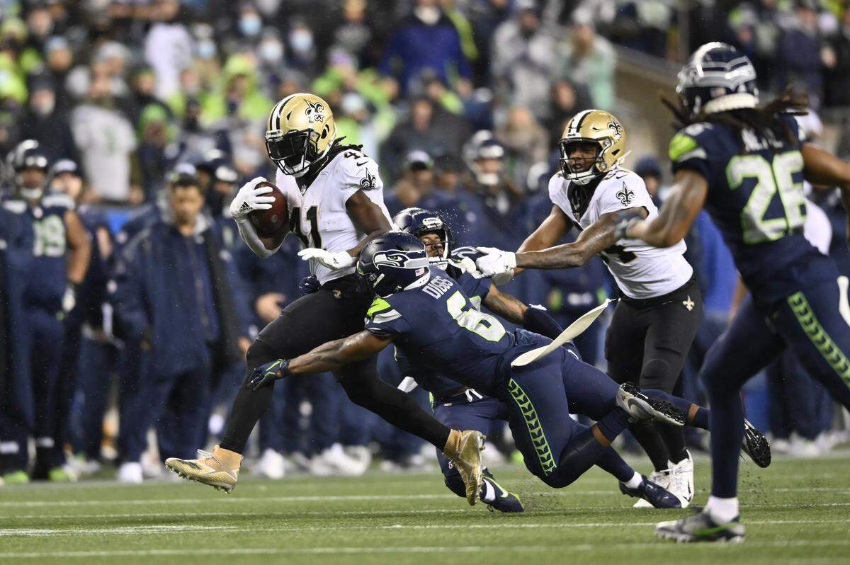 Oct 25, 2021; Seattle, Washington, USA; New Orleans Saints running back Alvin Kamara (41) runs the ball and breaks a tackle by Seattle Seahawks free safety Quandre Diggs (6) during the second half at Lumen Field. Mandatory Credit: Steven Bisig-USA TODAY Sports